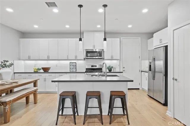a kitchen with white cabinets and stainless steel appliances