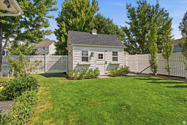 1257 Rigby Road Kaysville, UT 84037 - Photo 48 of 55 Fenced backyard featuring a storage shed with a shingled roof and cupola, surrounded by lush green lawn and mature trees