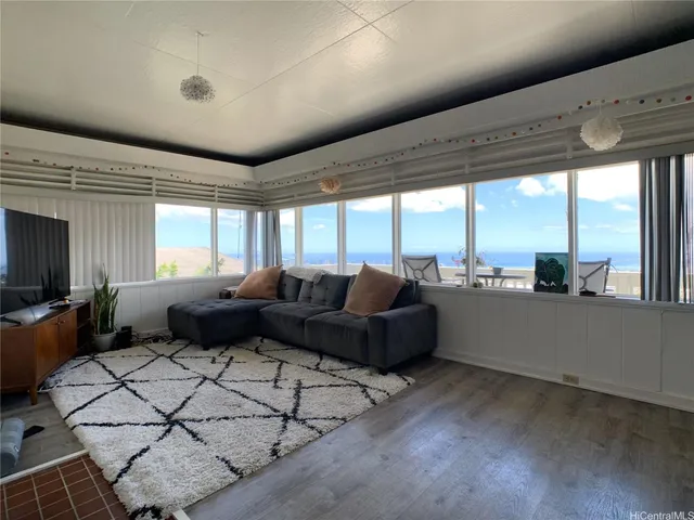 a living room with furniture wooden floor and large windows