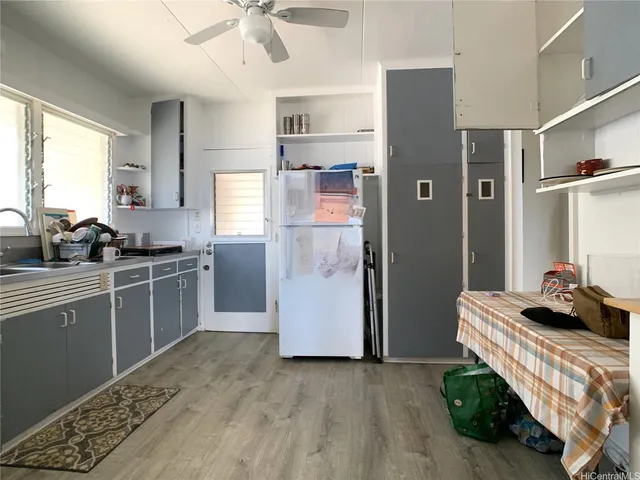 a kitchen with a refrigerator and white cabinets