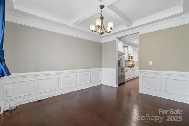 an empty room with windows fireplace and wooden floor