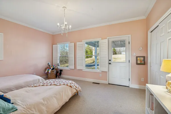 a spacious bedroom with a bed and a chandelier