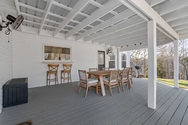 a dining room with furniture wooden floor a rug and a painting