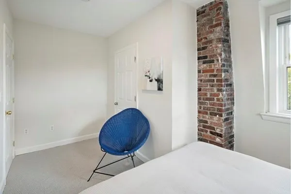 a bedroom with a bed and a chair