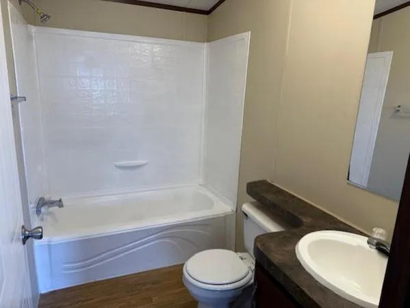 a white toilet sitting next to a bath tub