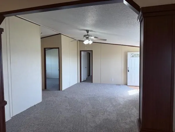 a view of a hallway with a chandelier fan and a closet