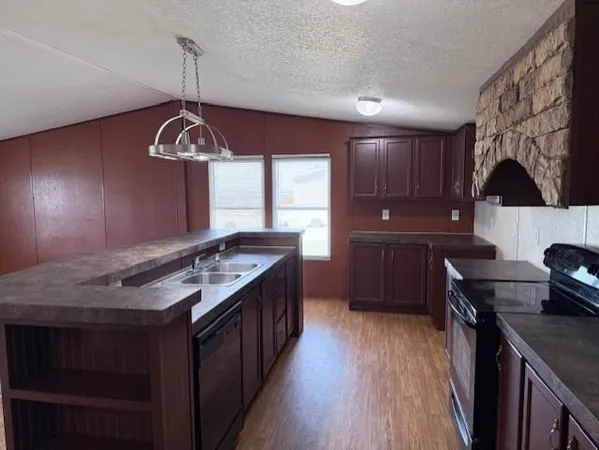 a kitchen with stainless steel appliances granite countertop a stove a sink dishwasher and a refrigerator