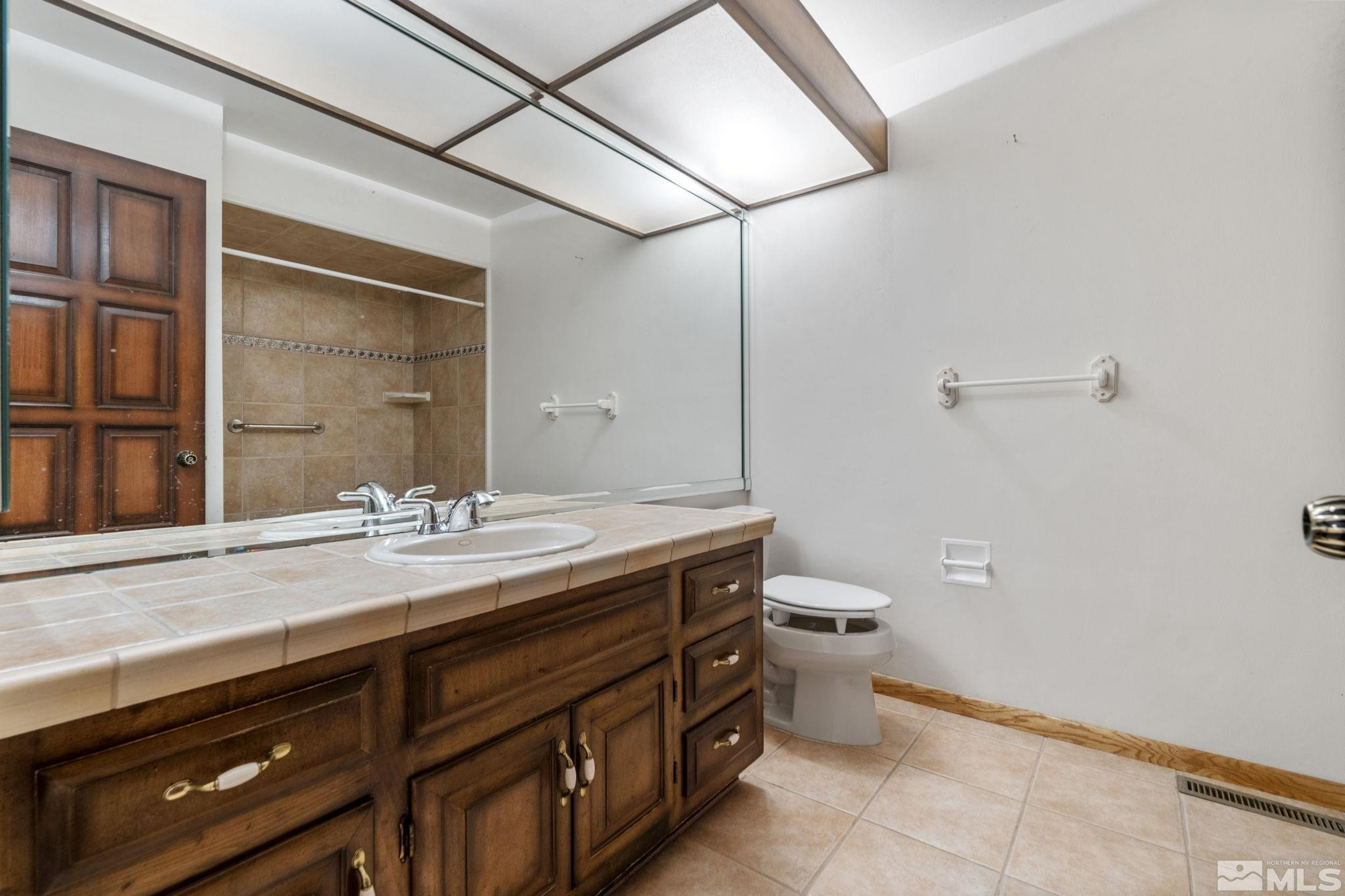 1575 Webster Way Reno, NV 89509 - Photo 26 of 40 a bathroom with a granite countertop sink a toilet and a mirror