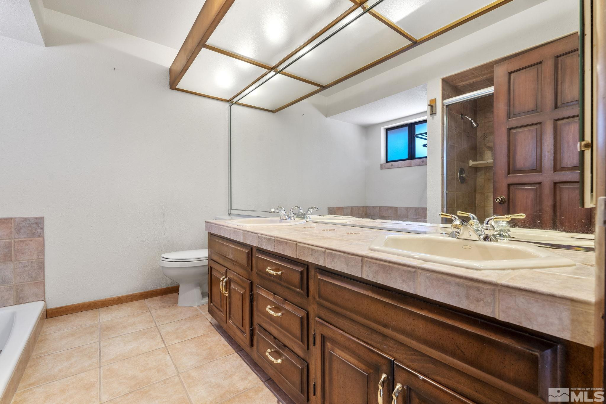 1575 Webster Way Reno, NV 89509 - Photo 30 of 40 a bathroom with a granite countertop sink a toilet and vanity
