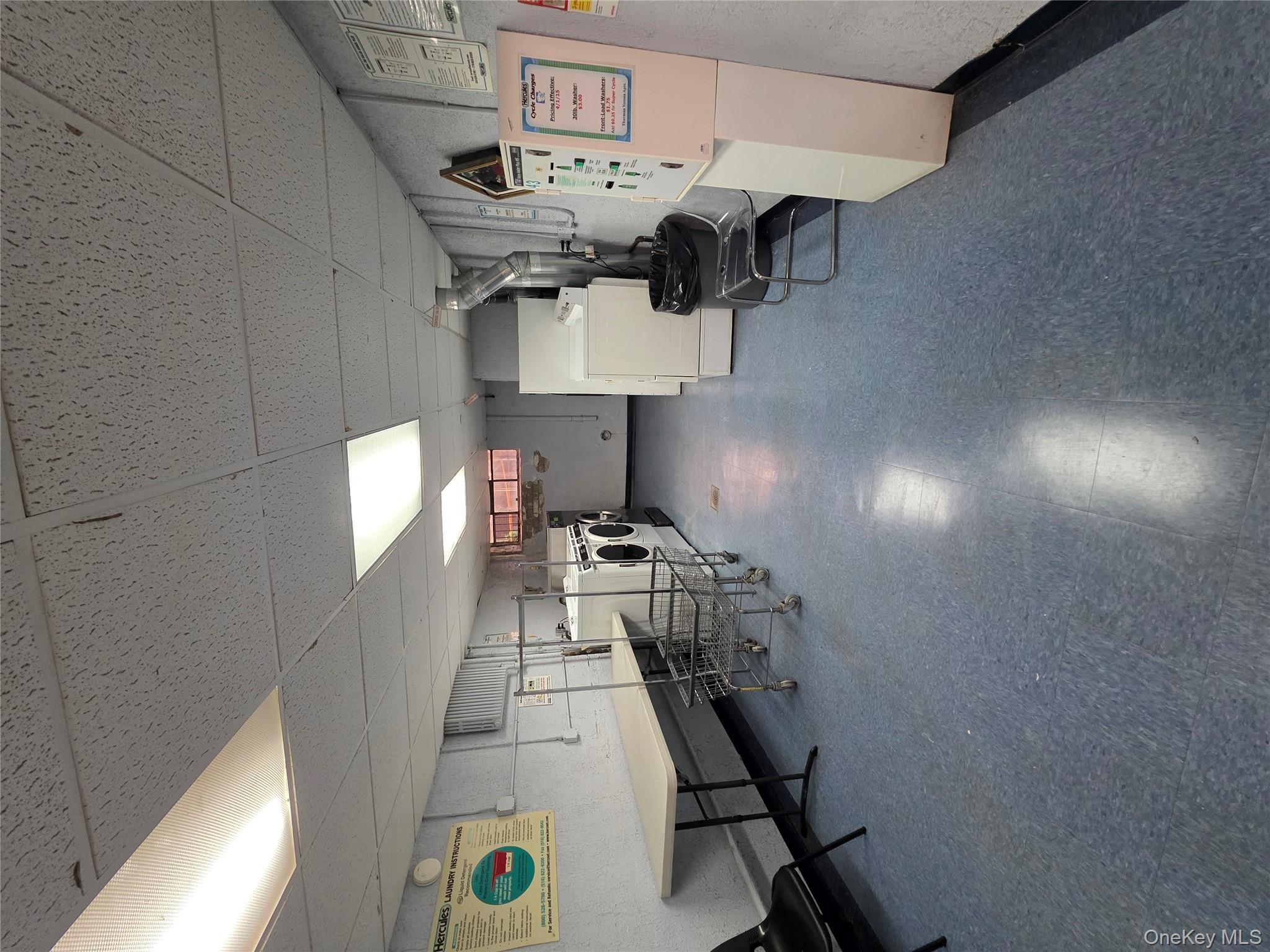 65-05 Yellowstone Boulevard, Unit 6C Queens, NY 11375 - Photo 11 of 11 Basement with dark flooring, a drop ceiling, and washer and dryer