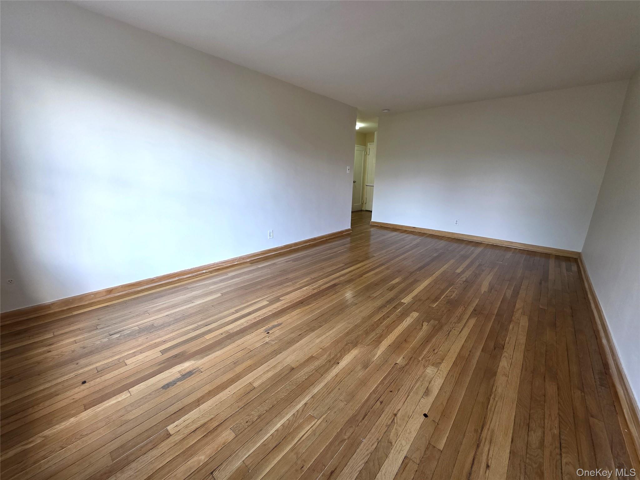 65-05 Yellowstone Boulevard, Unit 6C Queens, NY 11375 - Photo 4 of 11 Unfurnished room featuring hardwood / wood-style flooring and baseboards
