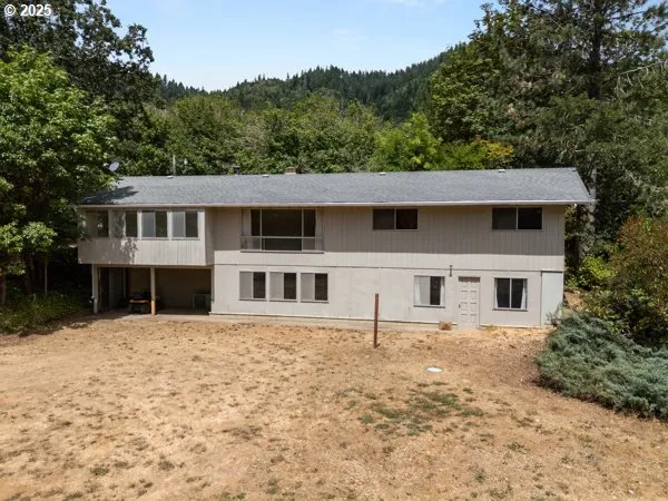 an aerial view of a house with a yard and greenery