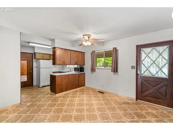 a kitchen with stainless steel appliances kitchen island granite countertop a refrigerator and a sink