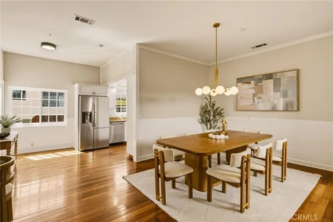 a kitchen with stainless steel appliances granite countertop white cabinets granite counter tops and a hard wood floors
