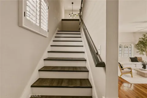 a view of a hallway with wooden floor and staircase