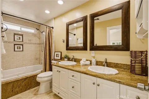a large white kitchen with stainless steel appliances granite countertop a stove a sink dishwasher and a microwave oven with a dining table