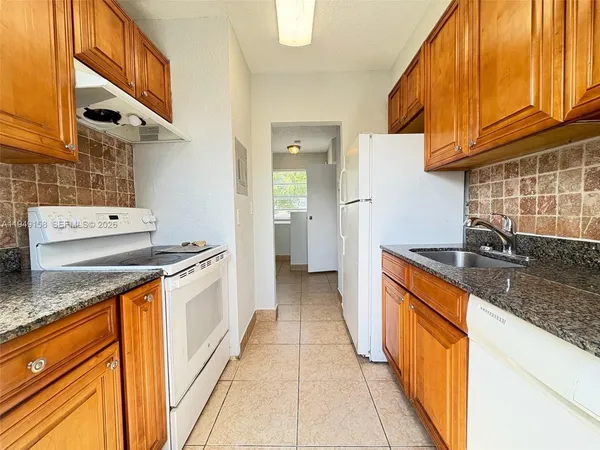 a kitchen with stainless steel appliances granite countertop a sink and cabinets