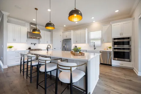a kitchen with a dining table cabinets and stainless steel appliances