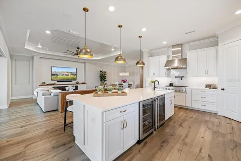 a kitchen with kitchen island granite countertop a stove a sink a center island and wooden floor