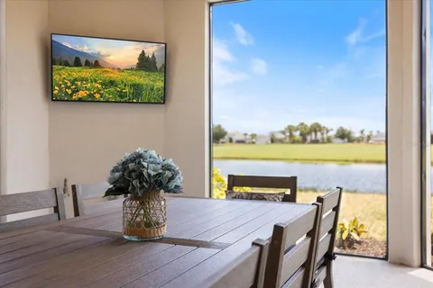 a dining room with furniture and a floor to ceiling window
