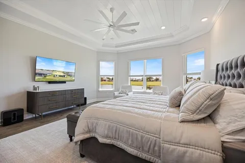 a bedroom with a bed a dresser and flat screen tv