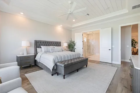 a bed sitting in a spacious bedroom next to a window