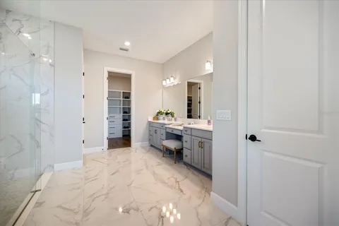a large white bathroom with a sink and a mirror
