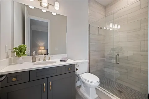 a bathroom with a sink a toilet and shower