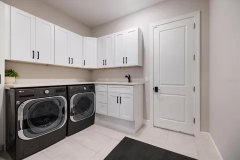 a utility room with sink dryer and washer