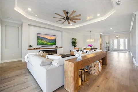 a living room with furniture a flat screen tv and a large window