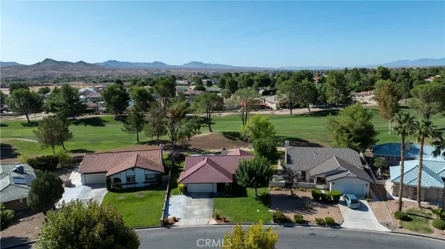 an aerial view of a residential apartment building with outdoor space and trees all around