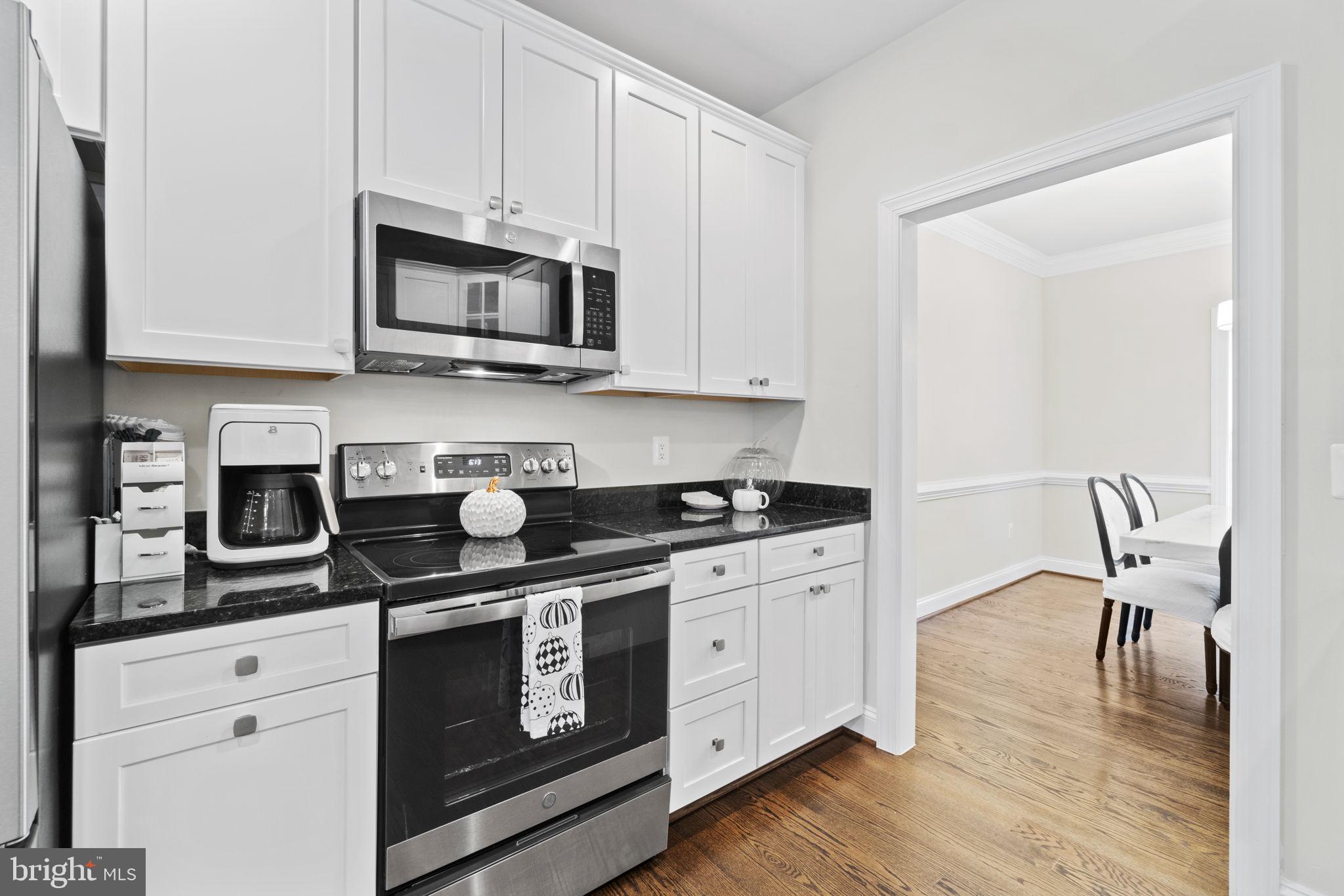 7946 Rogues Road Catlett, VA 20119 - Photo 11 of 50 a kitchen with stainless steel appliances granite countertop a stove a sink and white cabinets