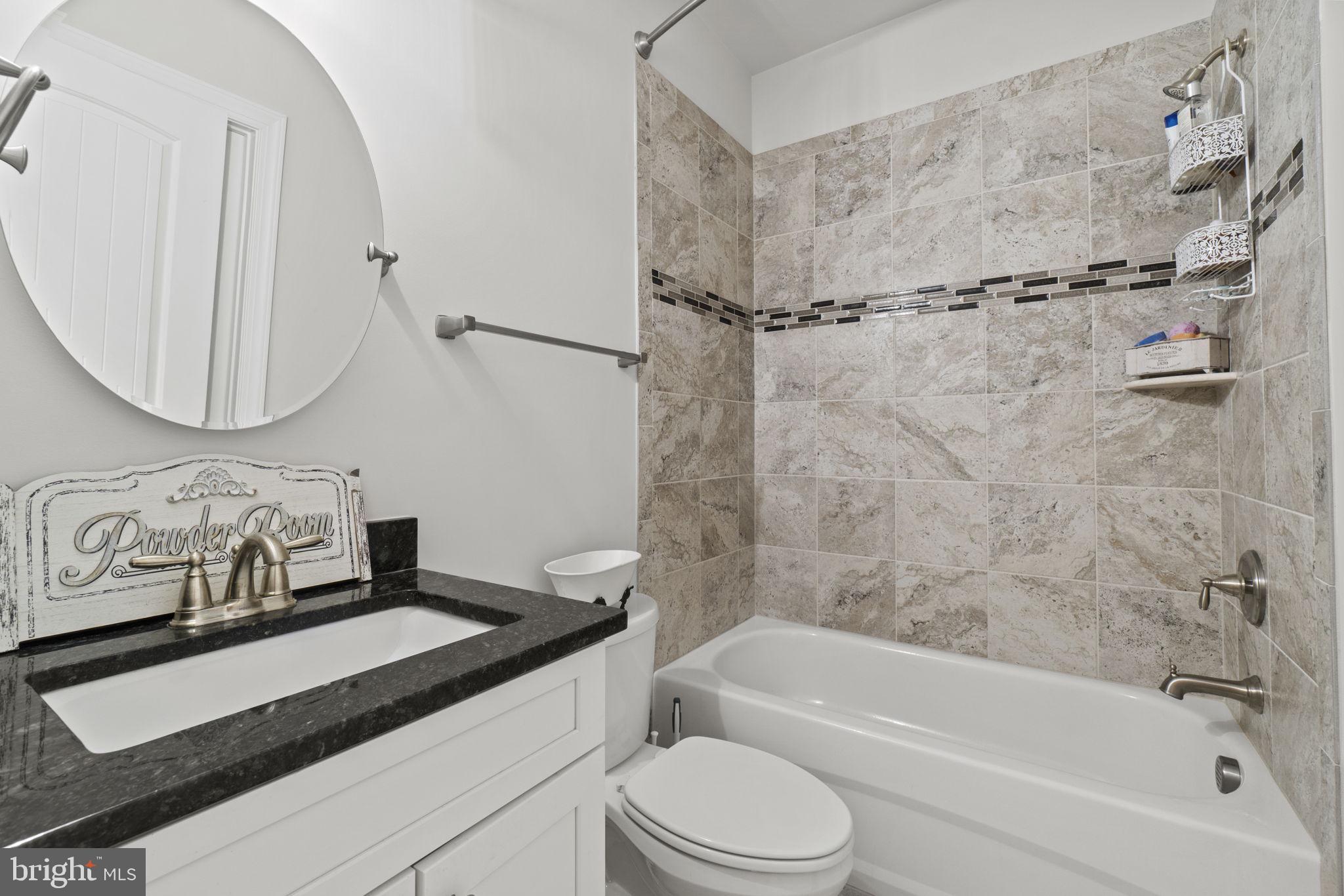 7946 Rogues Road Catlett, VA 20119 - Photo 19 of 50 a bathroom with a granite countertop sink a toilet and bathtub