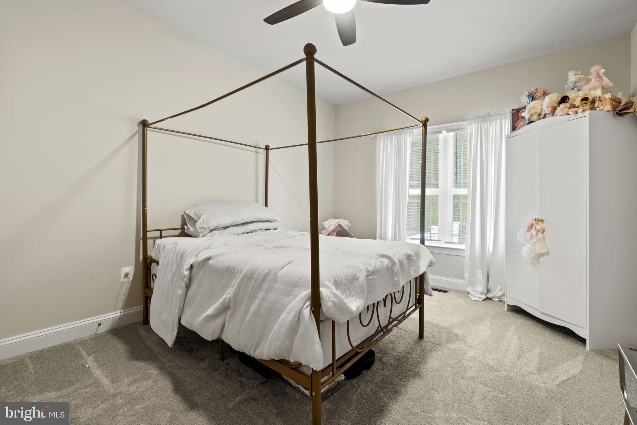 7946 Rogues Road Catlett, VA 20119 - Photo 21 of 50 a bed sitting in a bedroom next to a window and a chandelier