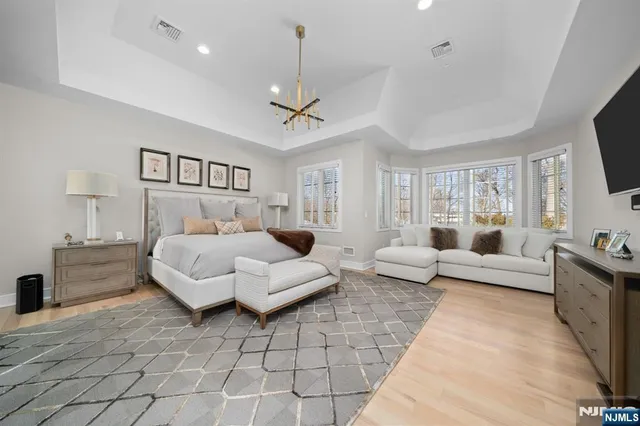 a bedroom with a bed a couch and a flat tv screen