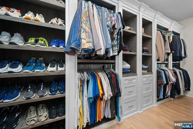a view of walk in closet with clothes and shoes