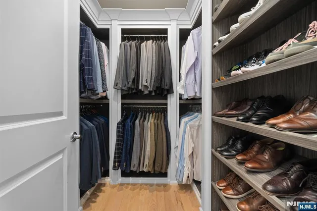 a view of walk in closet with clothes and shoes