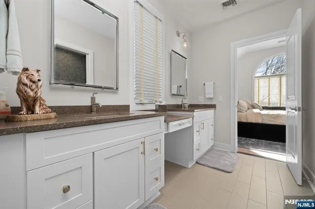 a large white kitchen with granite countertop white cabinets and a sink
