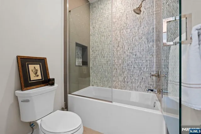 a white toilet sitting next to a bath tub