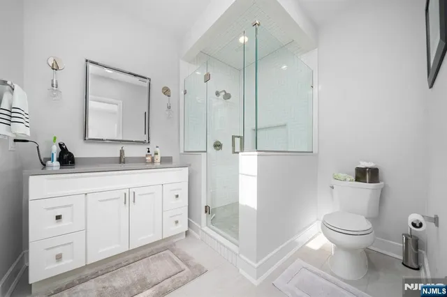 a spacious bathroom with a toilet a sink a mirror and a shower