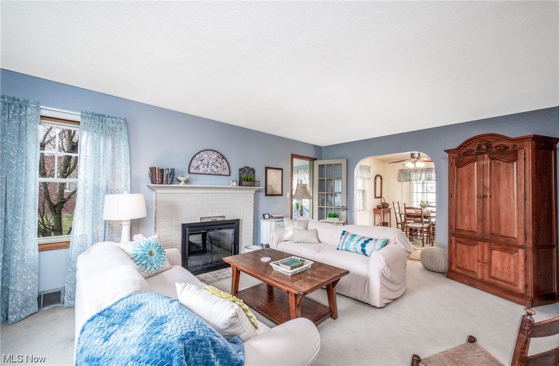 253 Butler Road Northeast Warren, OH 44483 - Photo 6 of 35 Carpeted living room with ceiling fan and a brick fireplace