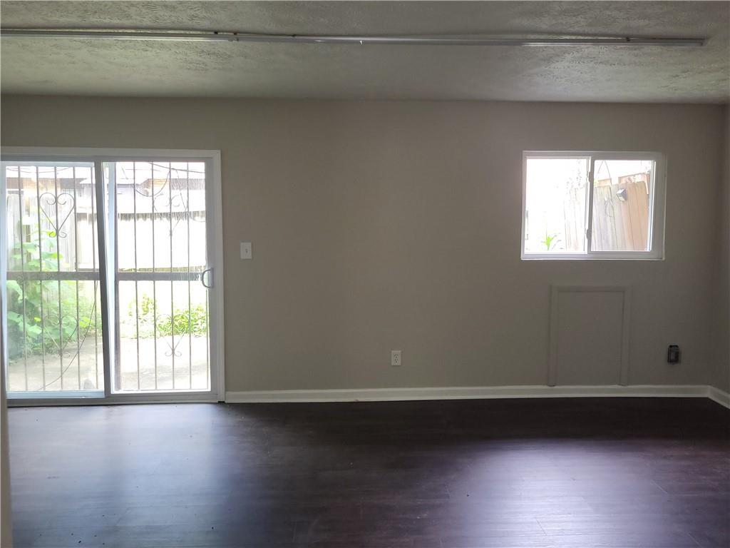 1867 Myrtle Drive Southwest, Unit 26 Atlanta, GA 30311 - Photo 2 of 15 an empty room with wooden floor and windows