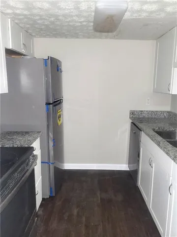 a kitchen with a stove refrigerator and microwave