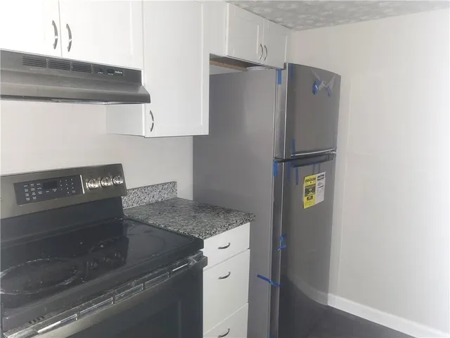 a kitchen with a refrigerator and a stove