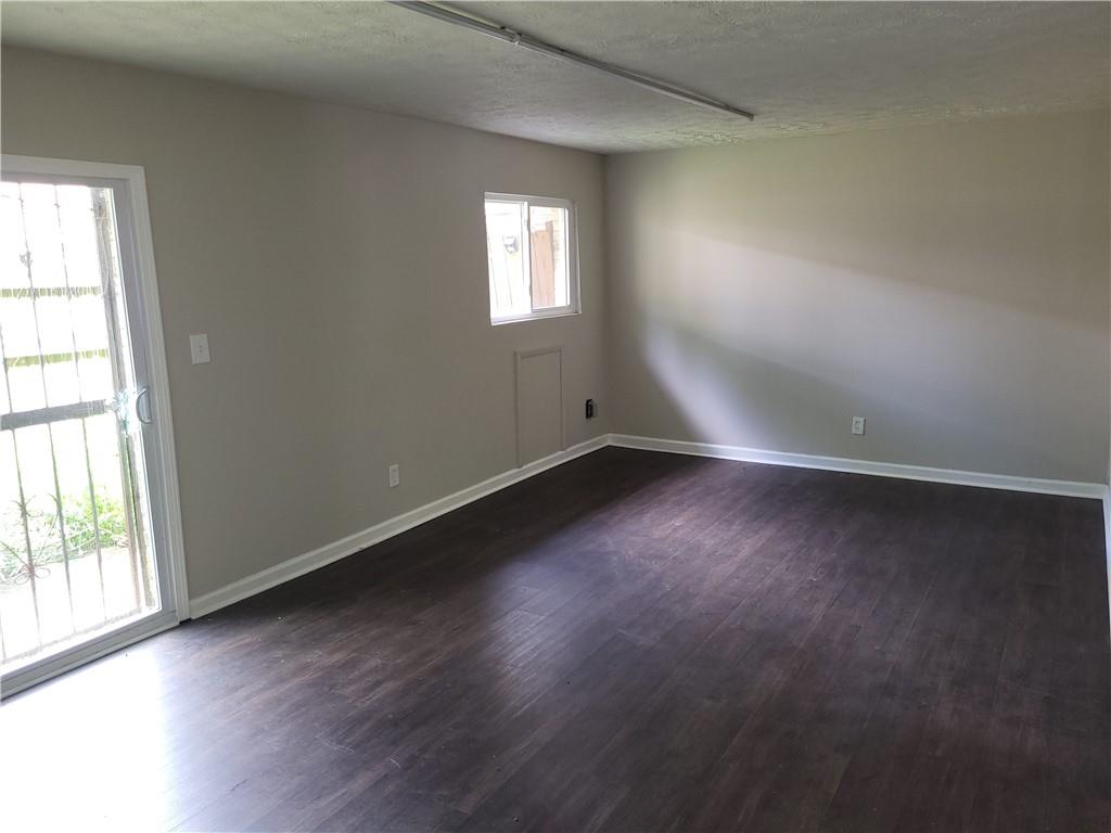 1867 Myrtle Drive Southwest, Unit 26 Atlanta, GA 30311 - Photo 8 of 15 an empty room with wooden floor and windows