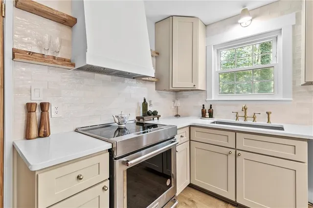 a kitchen with stainless steel appliances granite countertop a sink stove and cabinets