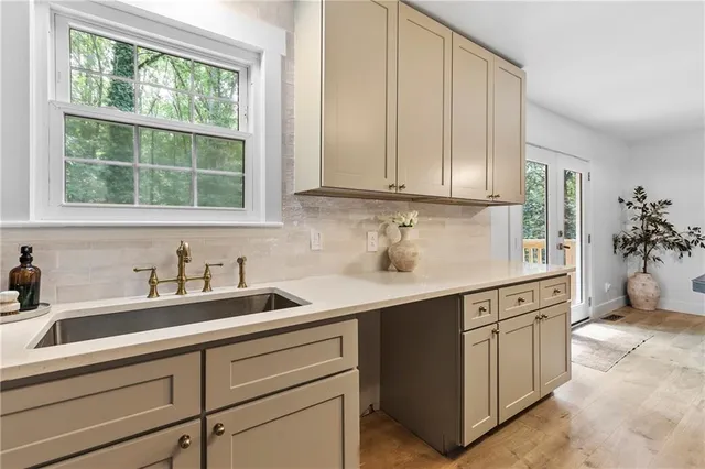 a kitchen with stainless steel appliances granite countertop a sink a stove and cabinets