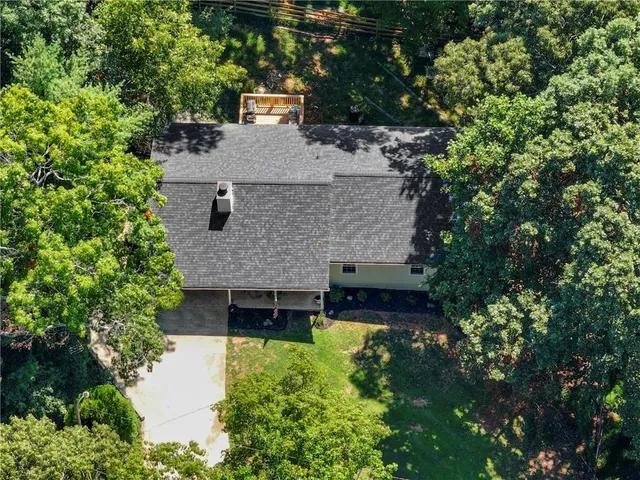 a aerial view of a house with a yard and large tree