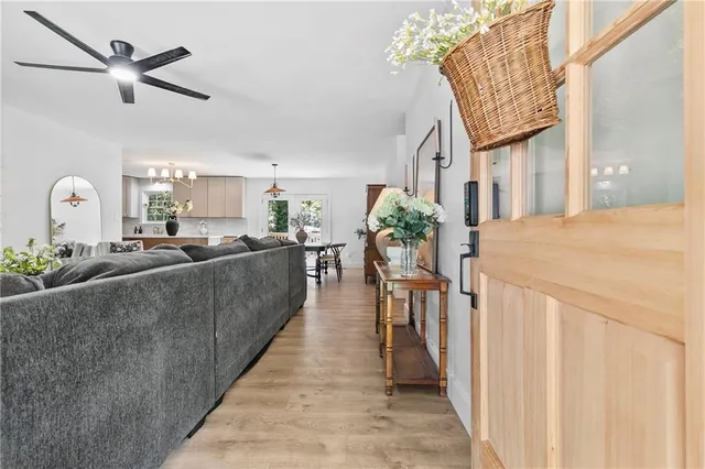 a living room with furniture a chandelier and a dining table
