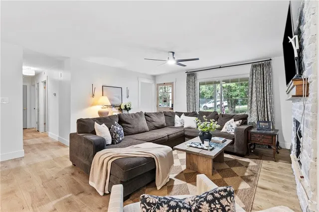 a living room with furniture a fireplace and a large window